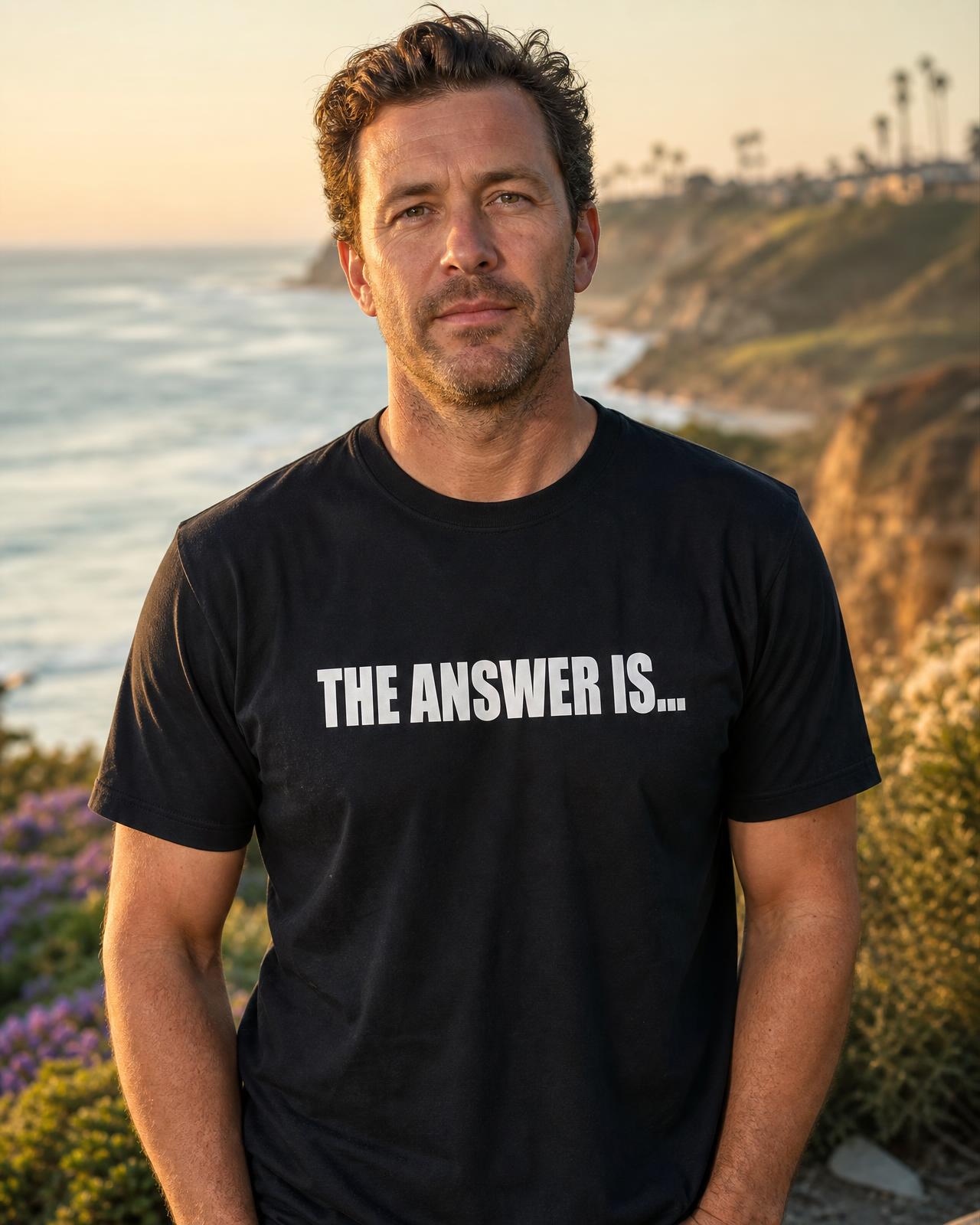 Man at a Southern California coastal bluff wearing a black THE ANSWER IS...® tee, front print visible